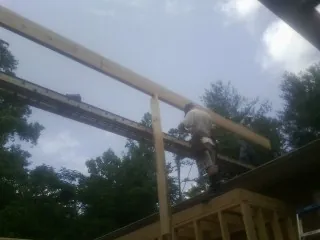 Carpenter setting a ridge beam over a new addition frame — Ice Dam Removal by Roofing Brothers in Topanga