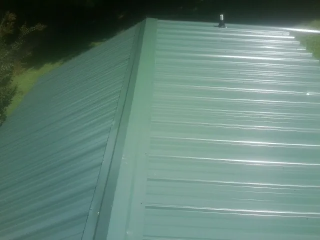 New green metal panels meeting at the ridge of a roof — Flat Roof Repair work by our crew in Topanga