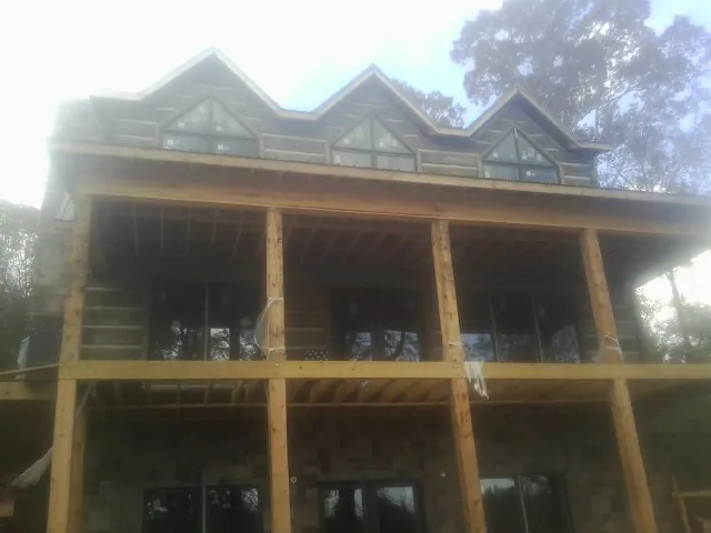 Dormers and porch framing on a large log home under construction — Roof Coating work by our crew in Topanga