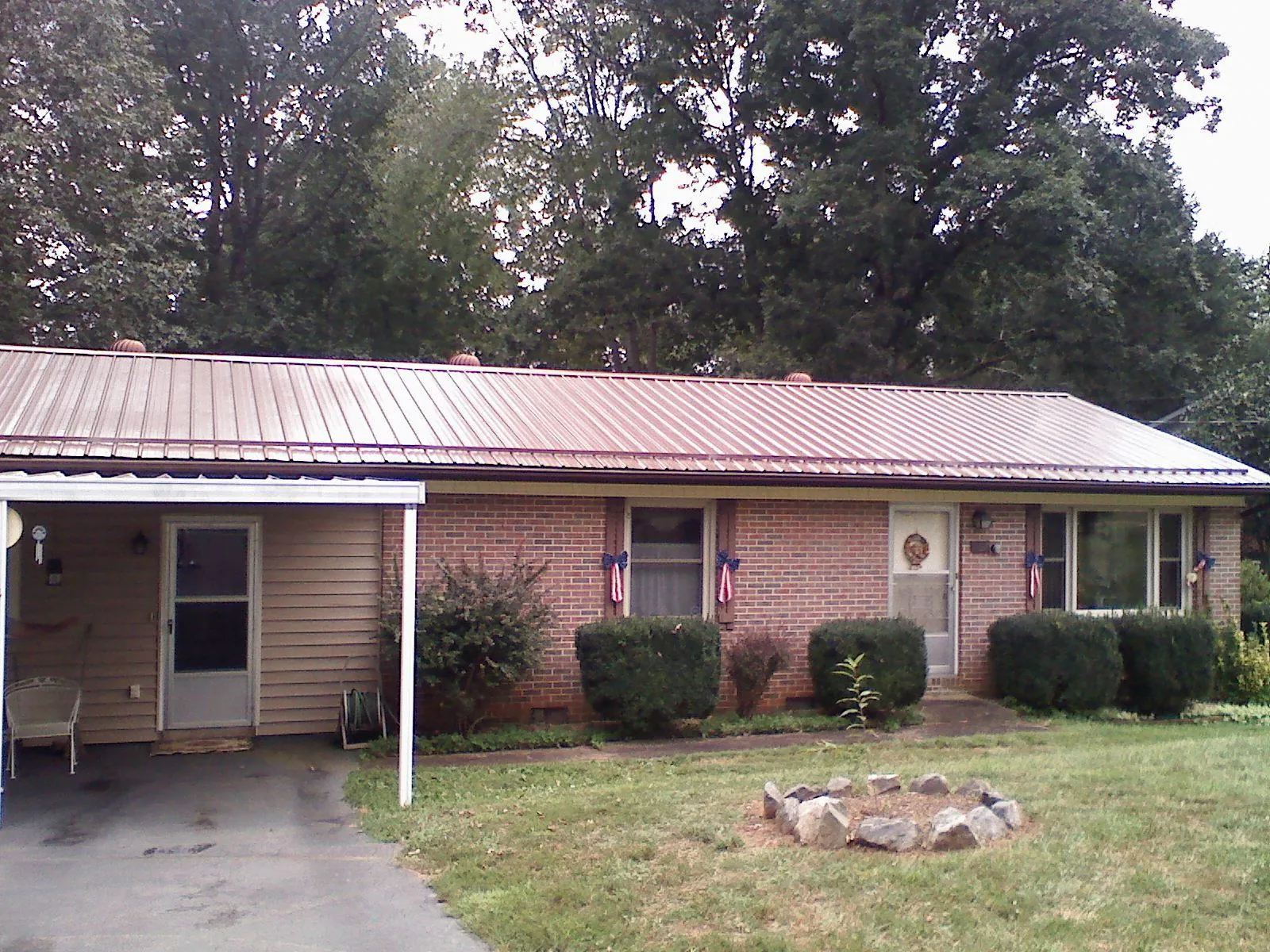 Bronze metal roof and carport on a brick ranch home — Roof Repair work by our crew in Topanga